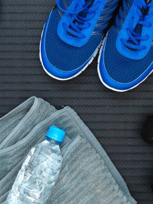 workout sneakers, a towel and a bottle of water, in preparation for exercise