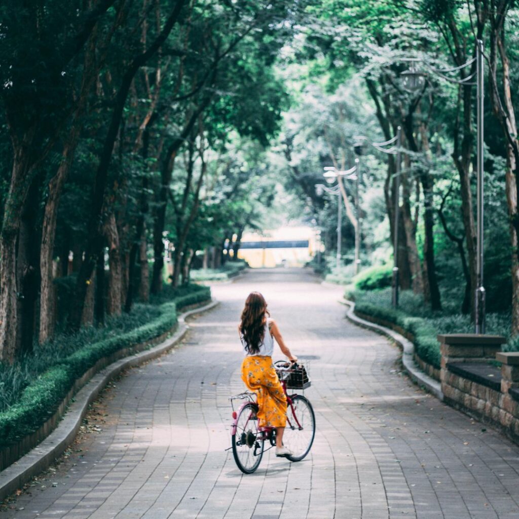 woman riding a bicycle down a windy path