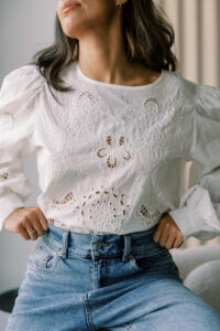woman in white shirt and jeans reflecting on her improved energy and healthy weight